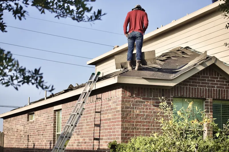 Professional roofer working on a residential roof in Cherry Hills Village